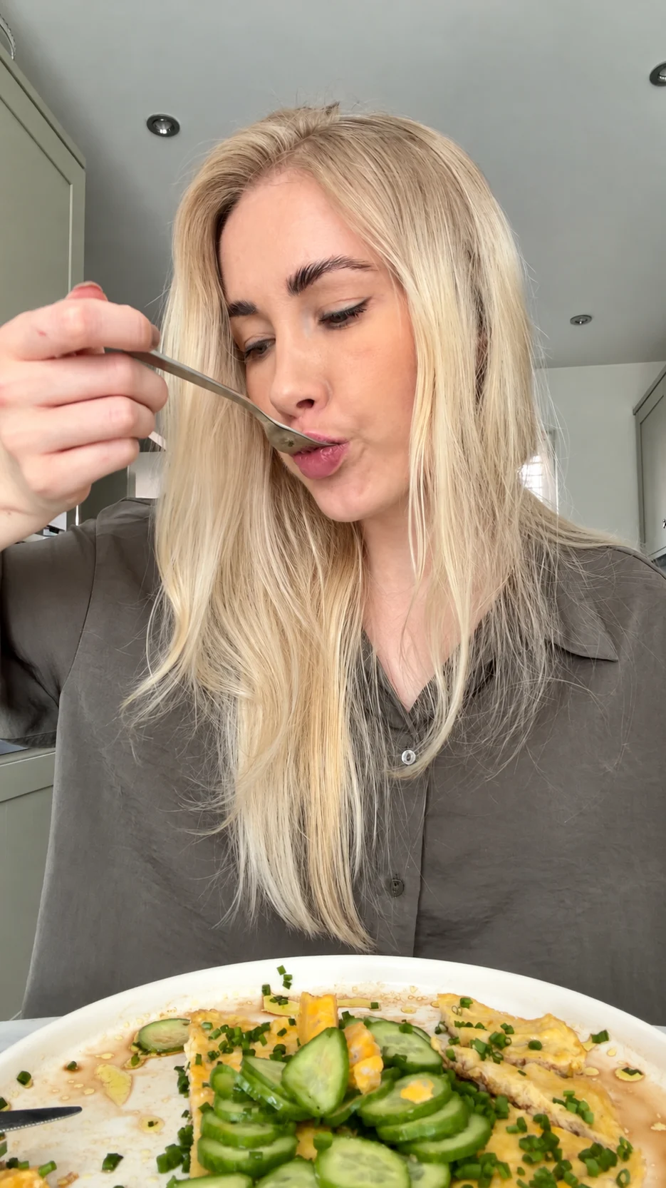 M Jones tasting her blue cheese omelette in her kitchen